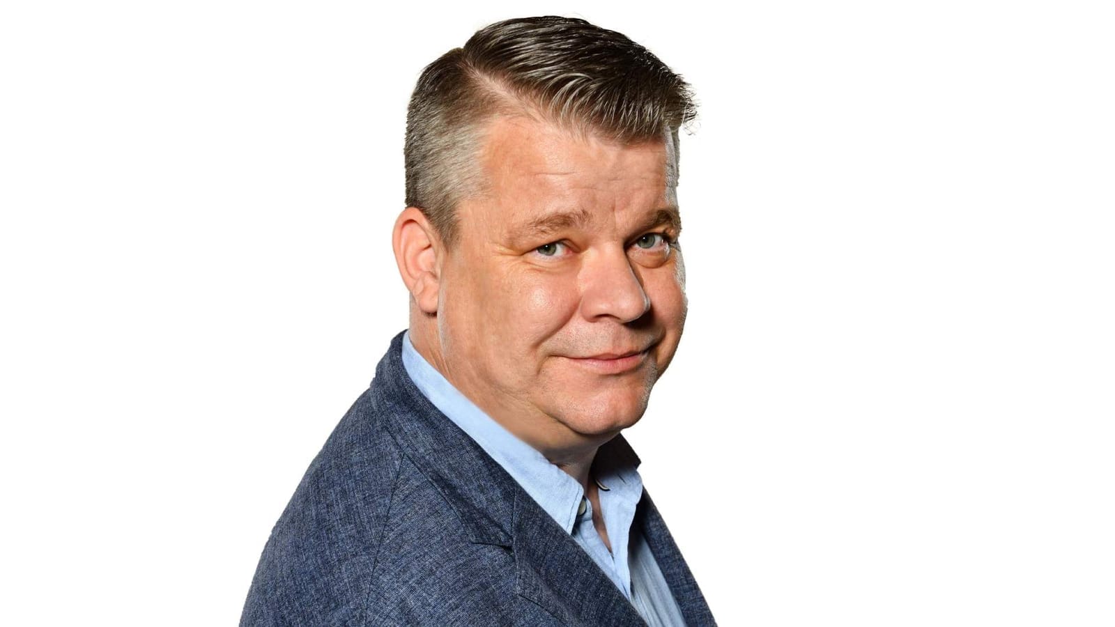 Studio portrait of Martin Švehlák in a blue jacket and light shirt against a white background