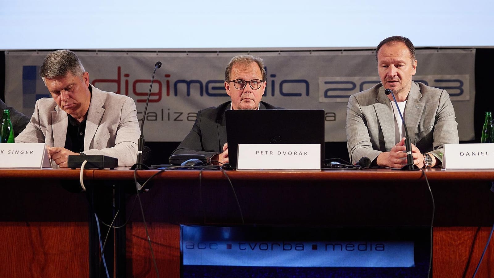 Marek Singer, Petr Dvořák and Daniel Grunt seated in jackets at a panel table before a Digimedia 2023 backdrop