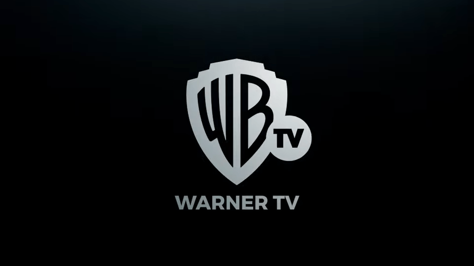 Silver Warner Bros. shield logo with "WB TV" and the caption "WARNER TV" on a black background
