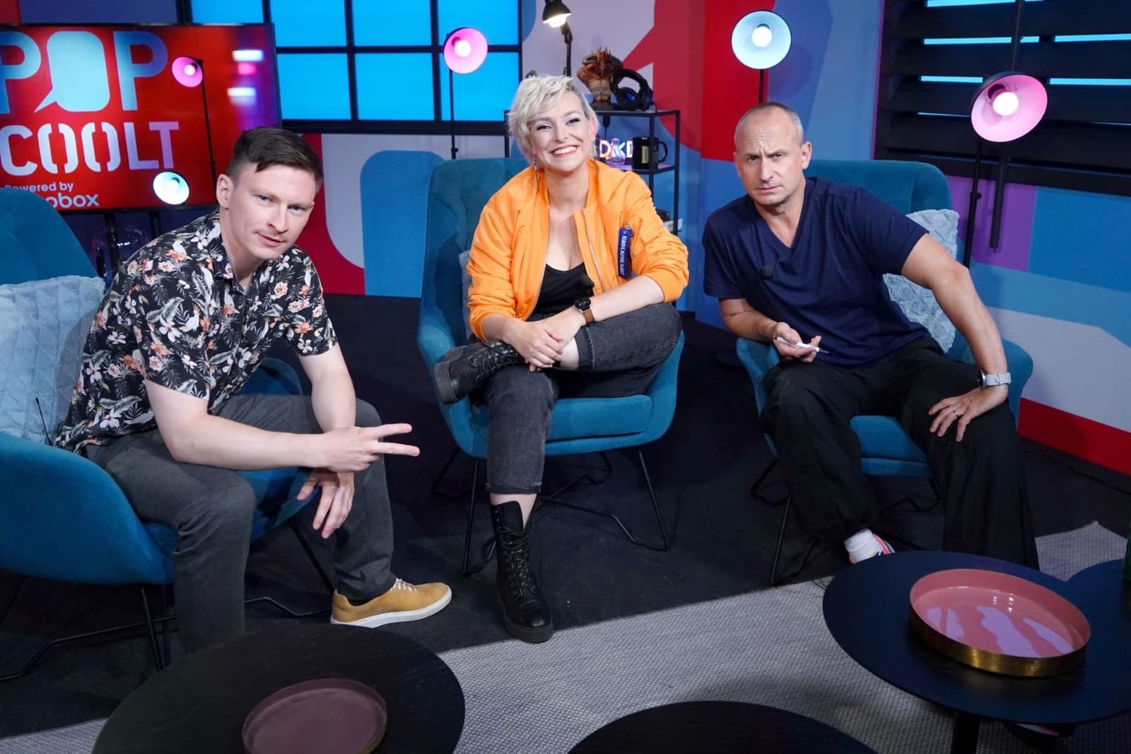 Three presenters on blue armchairs in a colourful studio, an illustrative photo of Prima Cool broadcasting