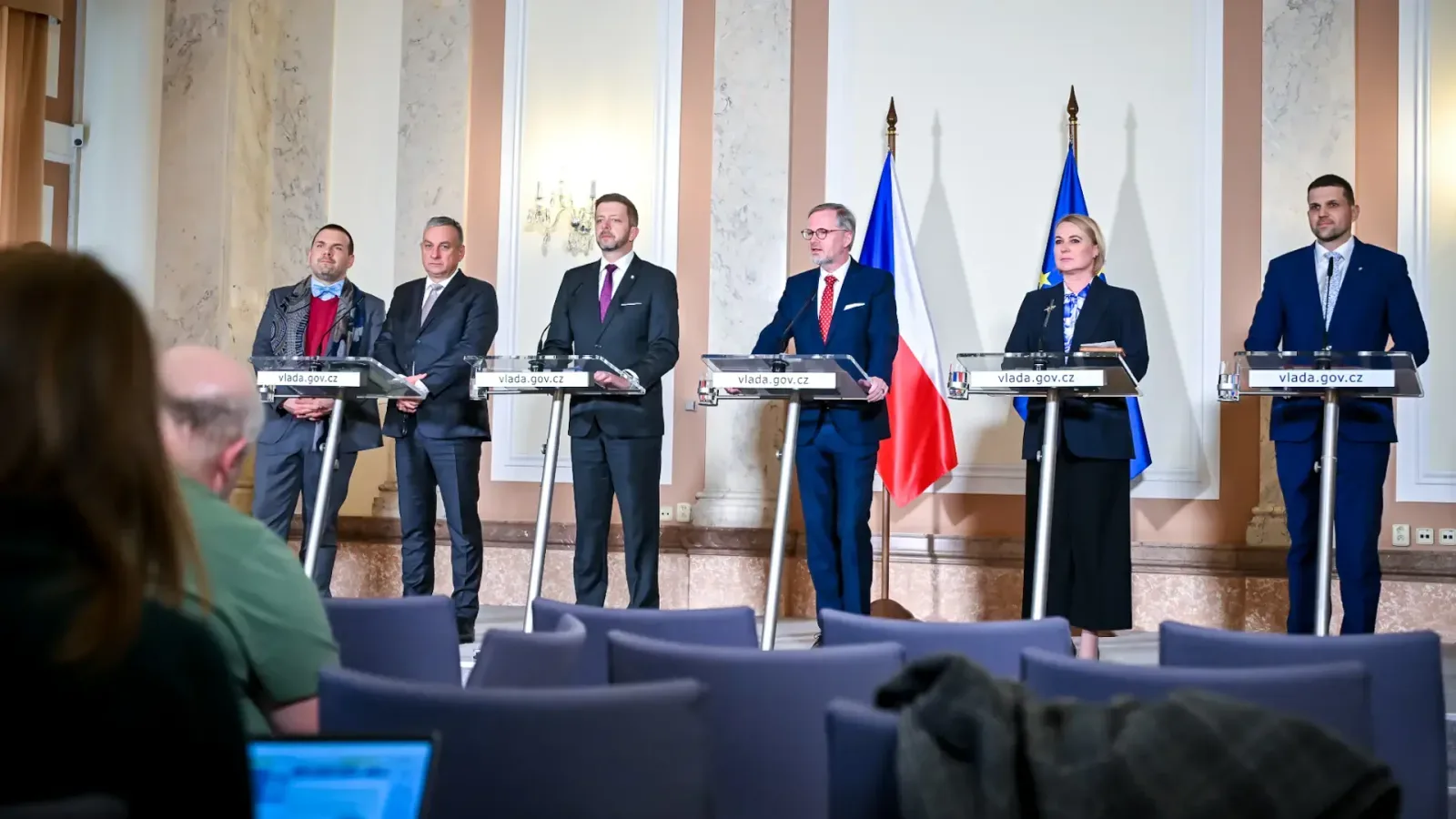 Six politicians at vlada.gov.cz lecterns before Czech and EU flags during a press conference after a Czech government meeting in 2024