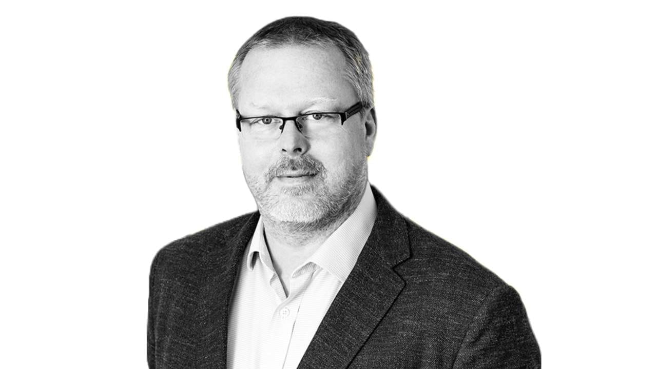Vadim Fojtík, bearded and wearing glasses and a dark jacket, in a black-and-white portrait against a white background